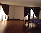 Large master bedroom with big windows and greenery