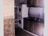 Big kitchen with washer and dryer next to an airwell. 