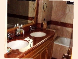 The Clayton: Master bathroom with marble tiles, long bath, shower cubicle.